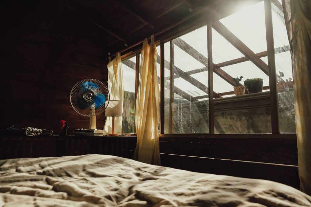 Canicule et sommeil : pourquoi la chaleur nous empêche de dormir (et comment y remédier) Chambre avec ventilateur pendant la canicule